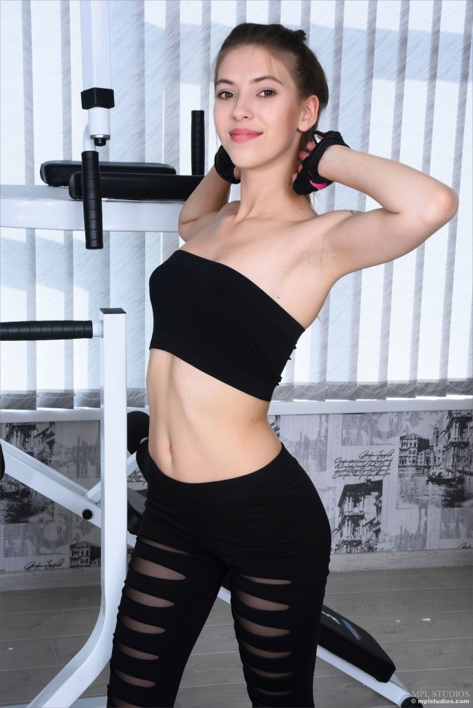 На фото голая спортивная девушка в тренажёрке.