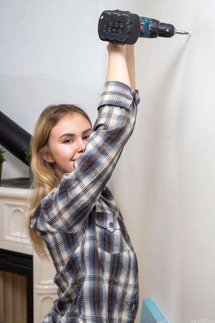 Голая Юлька вешает картину.