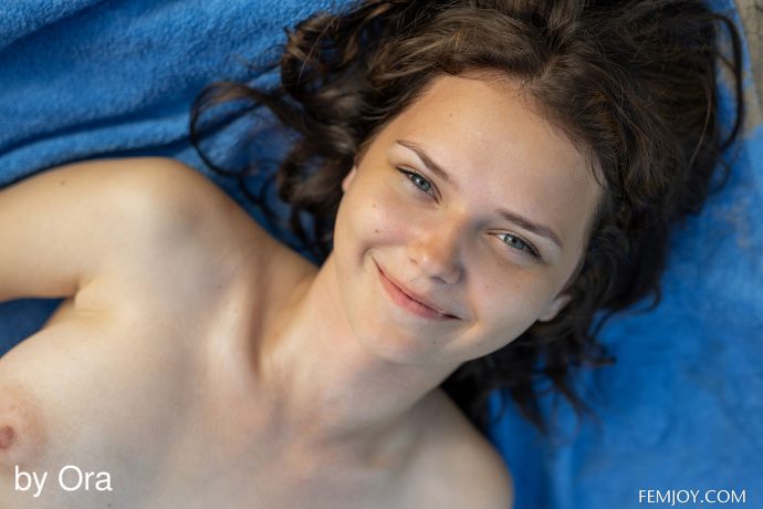 Голая студентка загорает на пляже.