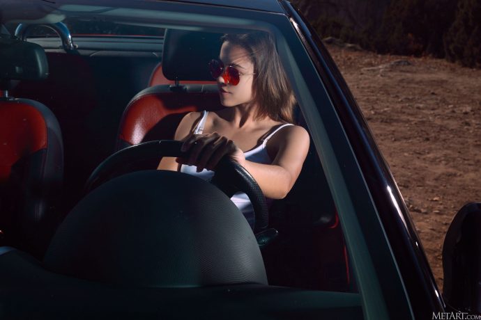 Голая девушка в кабриолете на фоне моря